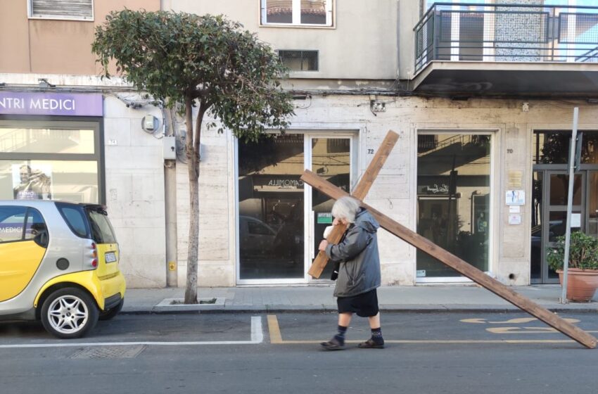 Donna percorre Corso Gelone con una croce di legno in spalla: la sua foto diventa virale